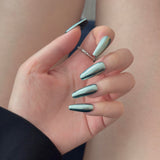 Close-up of a hand wearing MyLilith's metallic chrome press-on nails with a shiny, reflective finish, in an coffin shape.