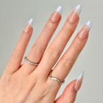 Close-up of a hand wearing MyLilith's press-on nails with a nude base and iridescent chrome tips, in an almond shape.