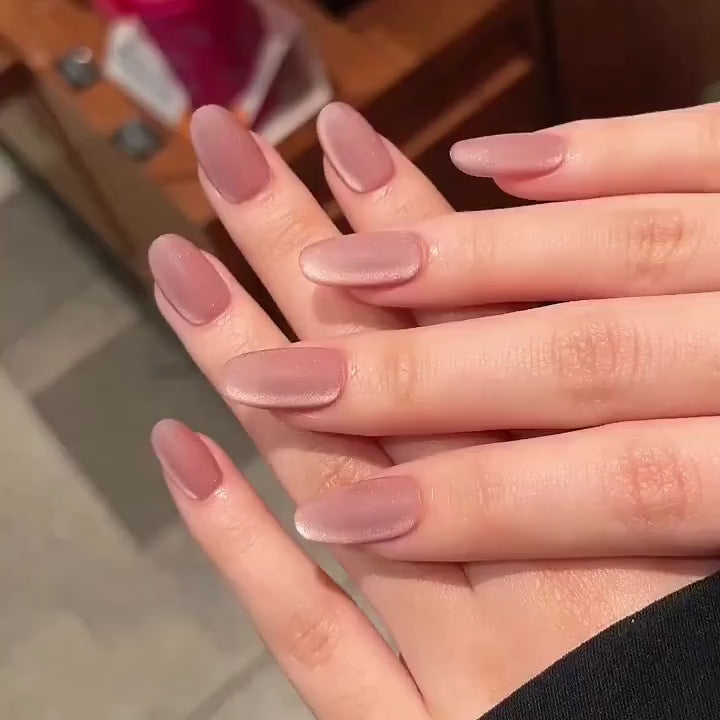 Video of two hands wearing MyLilith's Red Velvet Cat-Eye matte press-on nails with a short round shape. With the nails giving off a shine as the wearer moves.