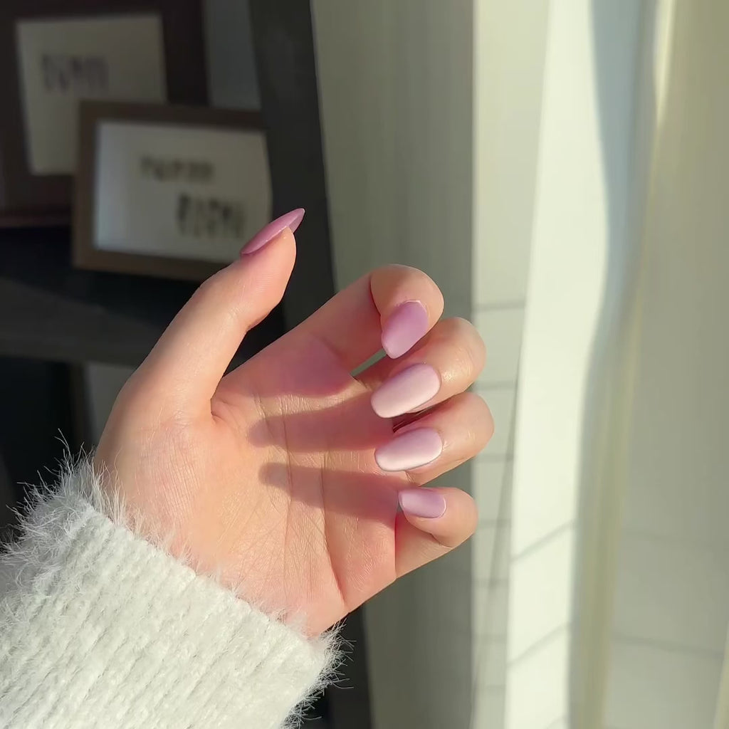 Video of two hands wearing MyLilith's Red Velvet Cat-Eye matte press-on nails with a short round shape. With the nails giving off a shine as the wearer moves.