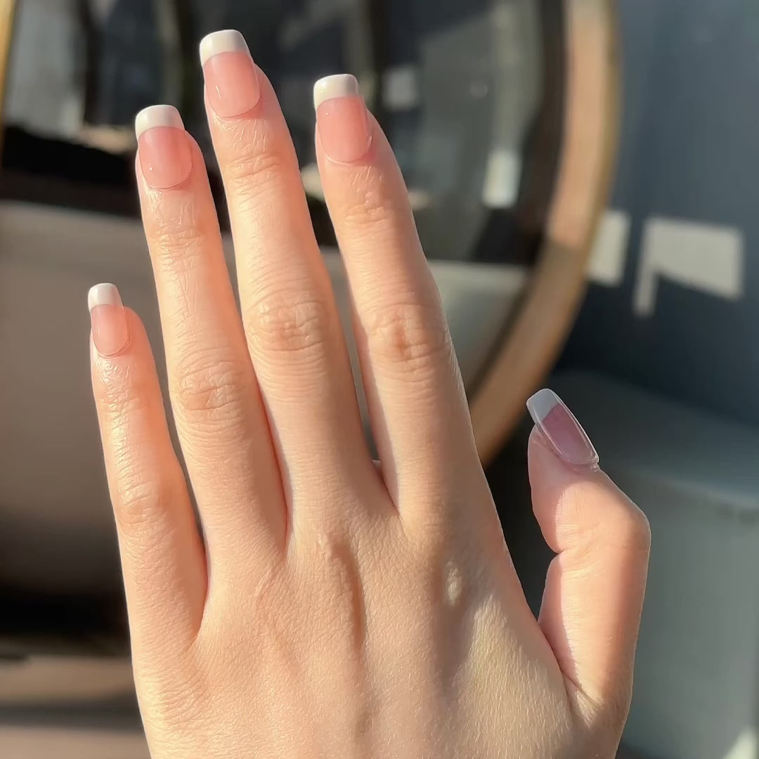 Video of a hand wearing MyLilith's French manicure press-on nails with a pink glossy finish, in a short, coffin shape.